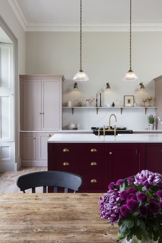 harvey jones kitchen with red island pink cabinetry and wooden floor 2