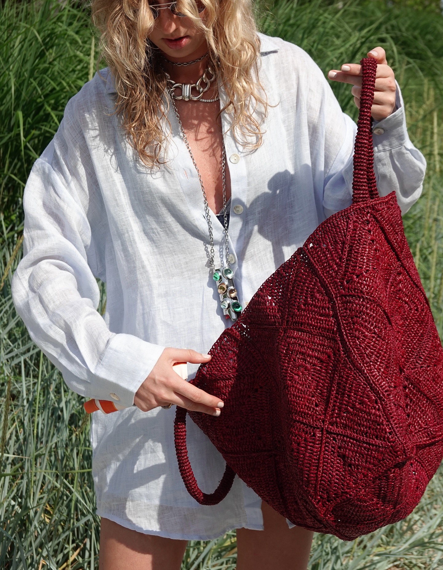 maggie klimuszko wears a white shirt dress and a red basket bag
