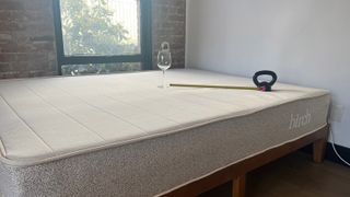 A wine glass and tape measure on the Birch Natural Mattress