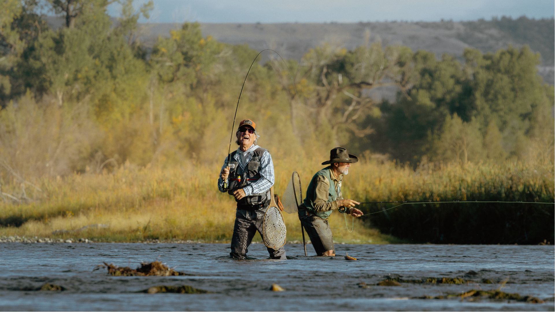 a production image from The Madison showing Kurt Russell and Matthew Fox fishing in the river