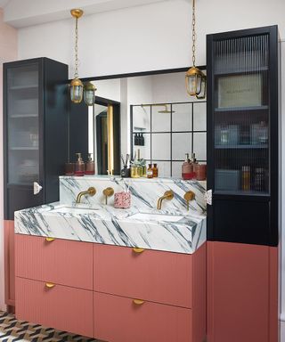Bathroom with two tall storage units either side of a vanity unit, painted terracotta