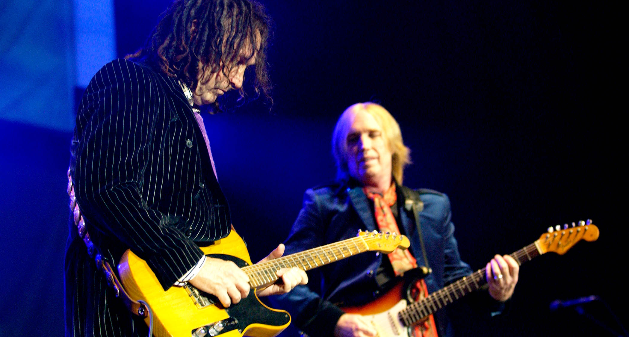 Mike Campbell takes a solo on his Telecaster while Tom Petty looks on.