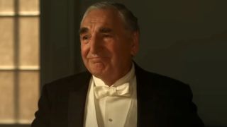 Jim Carter smiles tearfully in a tuxedo in Downton Abbey: The Grand Finale.