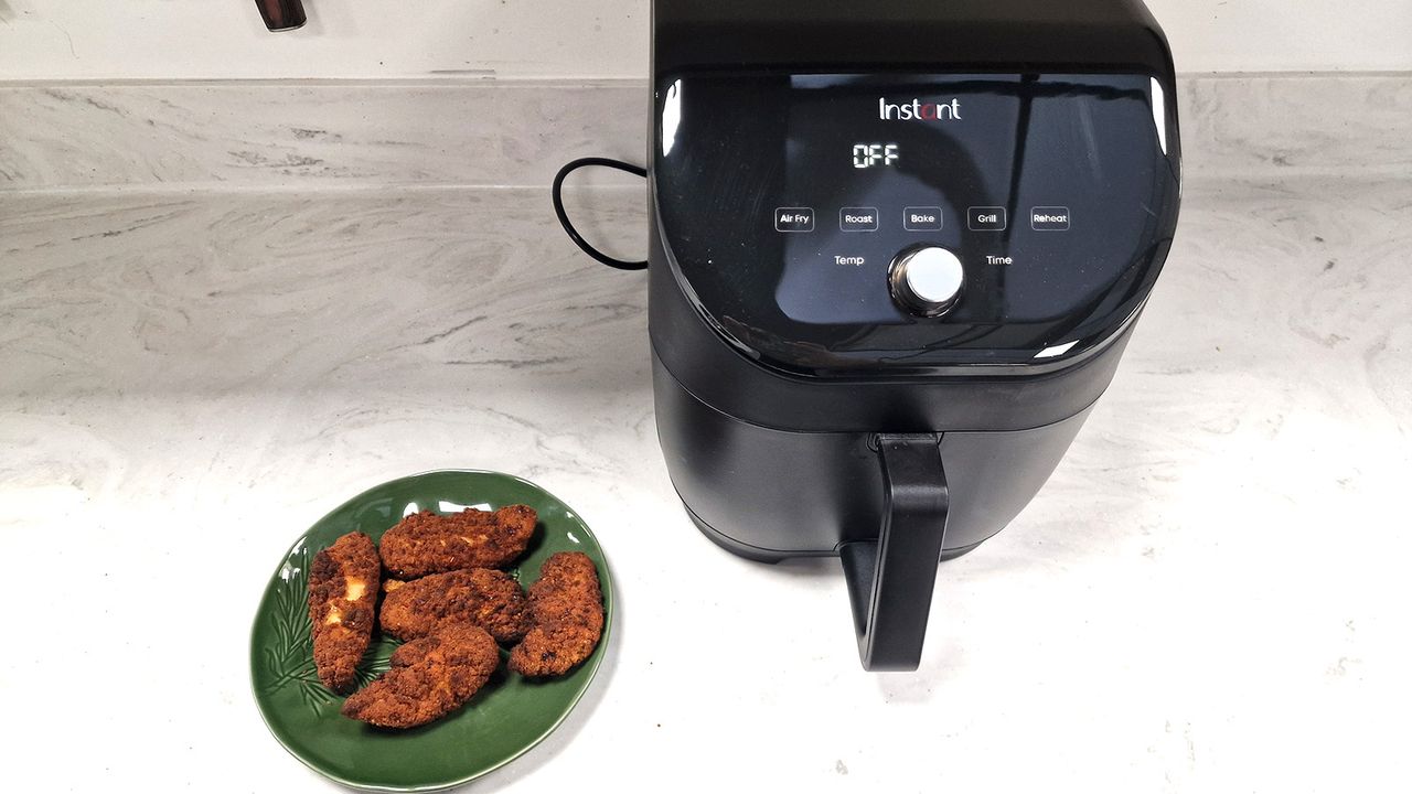 Plate of crispy chicken tenders next to the Instant Vortex Slim XL Air Fryer