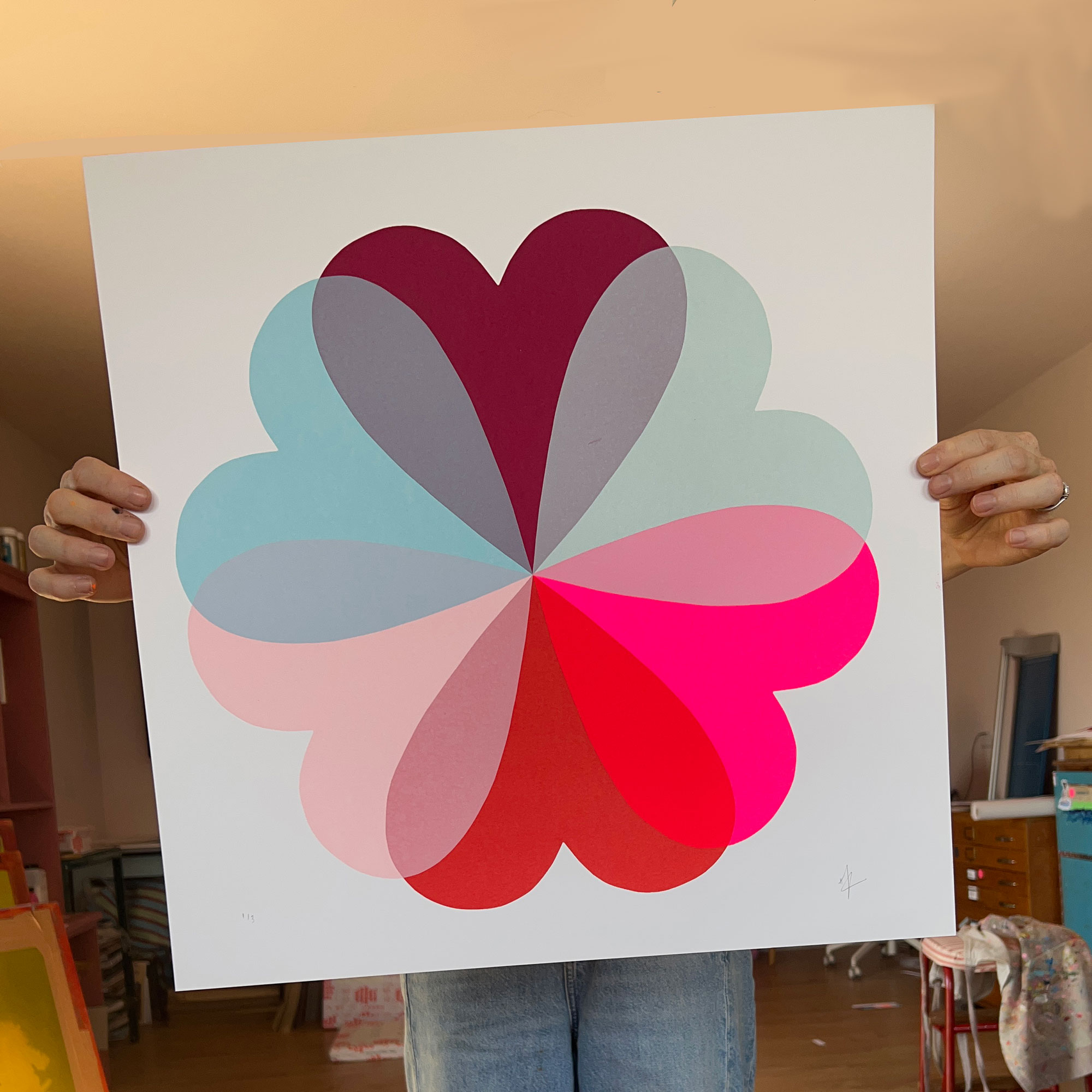 Person holding pink and blue flower screen print in front of them