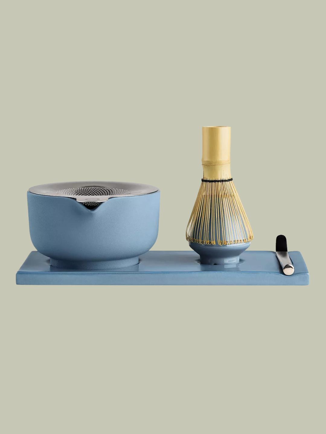 A blue matcha set from Fellow with a bowl, a sieve, a whisk, a spoon, and a holder