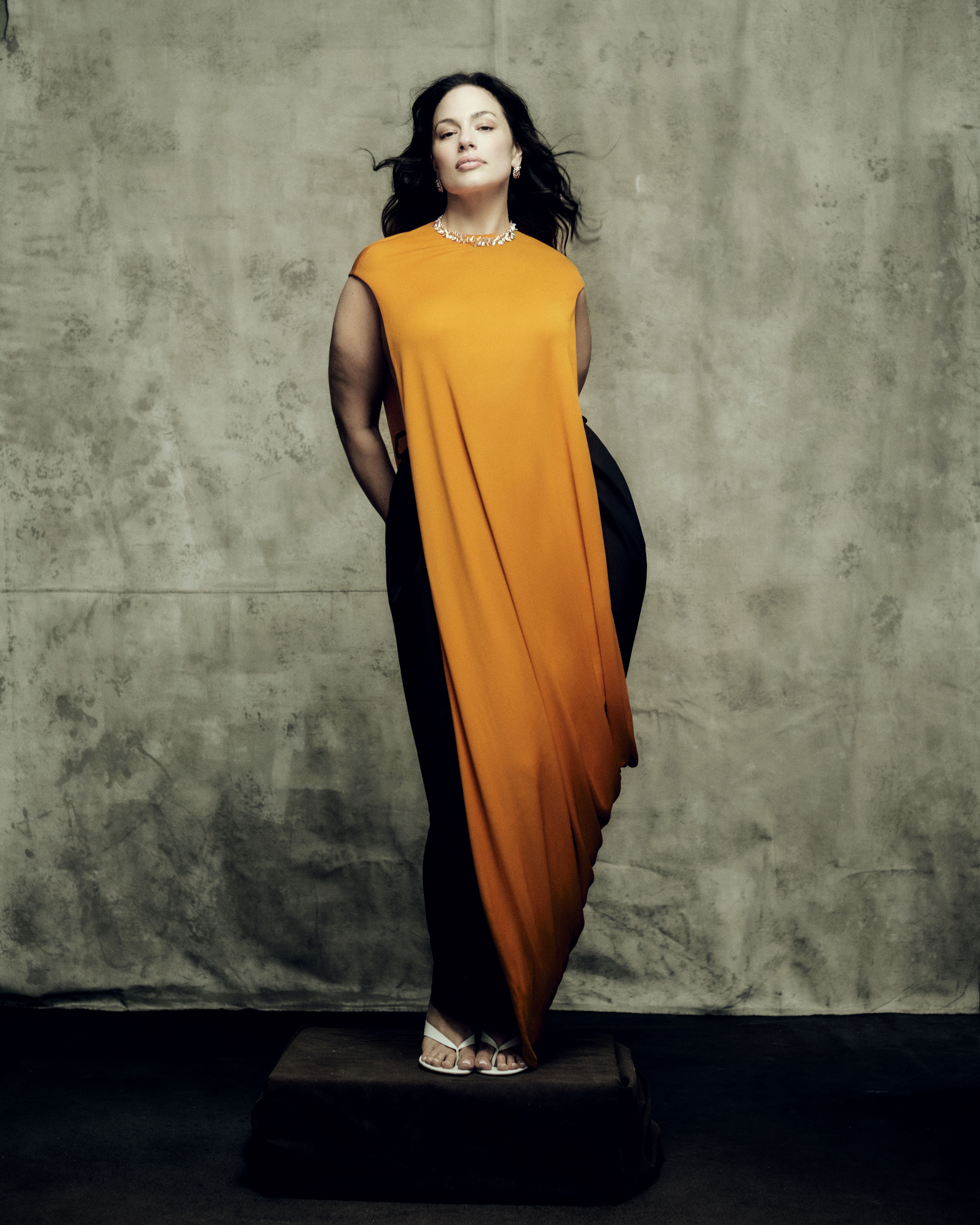 Ashley Graham poses in an orange dress for a Marie Claire cover story
