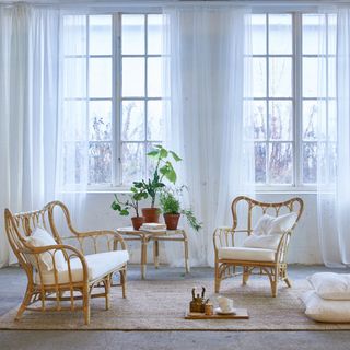 white living space with carpet flooring and long white curtains