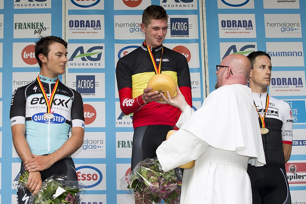 One of the Trappist monks from the Postel Abbey presents Van Den Broeck with a cheese prize.