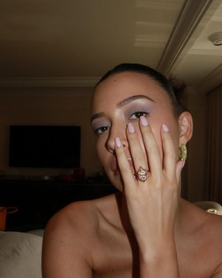 Christian Serratos wearing a pink diamond engagement ring with a red enamel band.