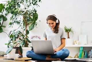 woman working from laptop with over ear headphones