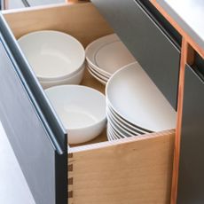 A kitchen drawer full of white ceramic tableware