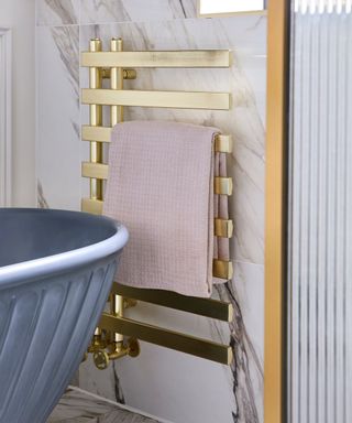 gold effect towel radiator with pink towel