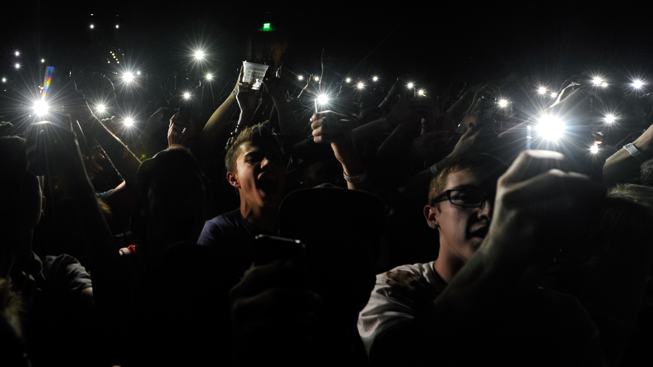 Fans using their smartphones to record a concert