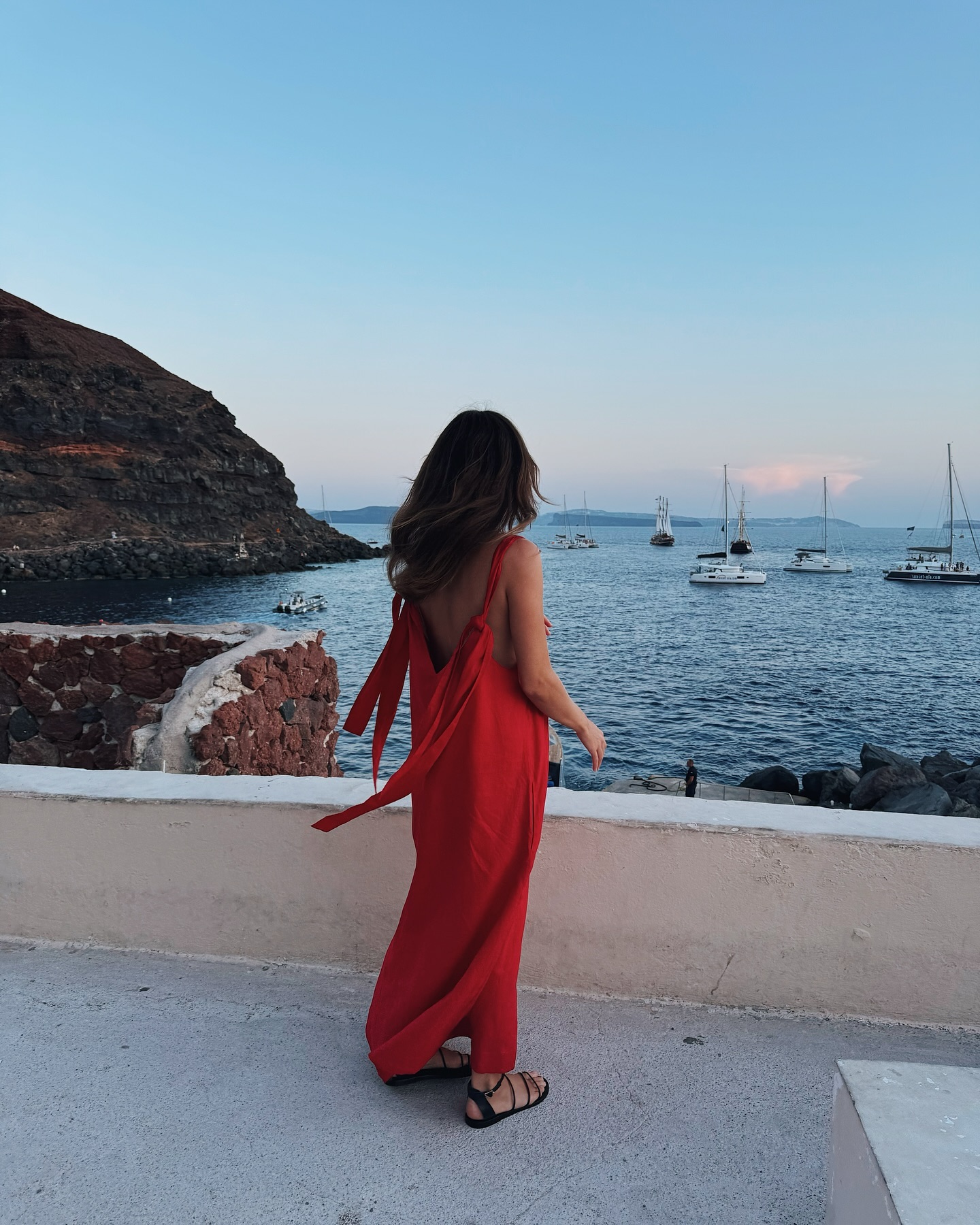Woman wears red dress and black strappy sandals