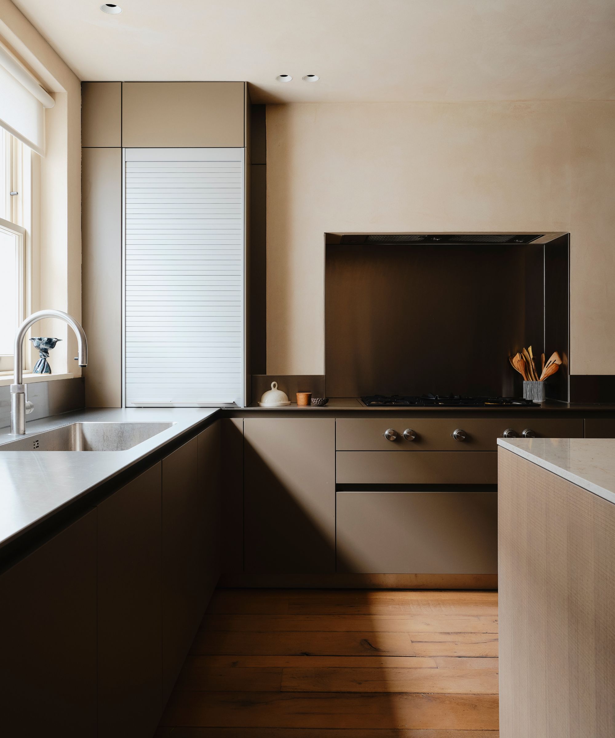 Minimalist dark green kitchen with plaster toned walls