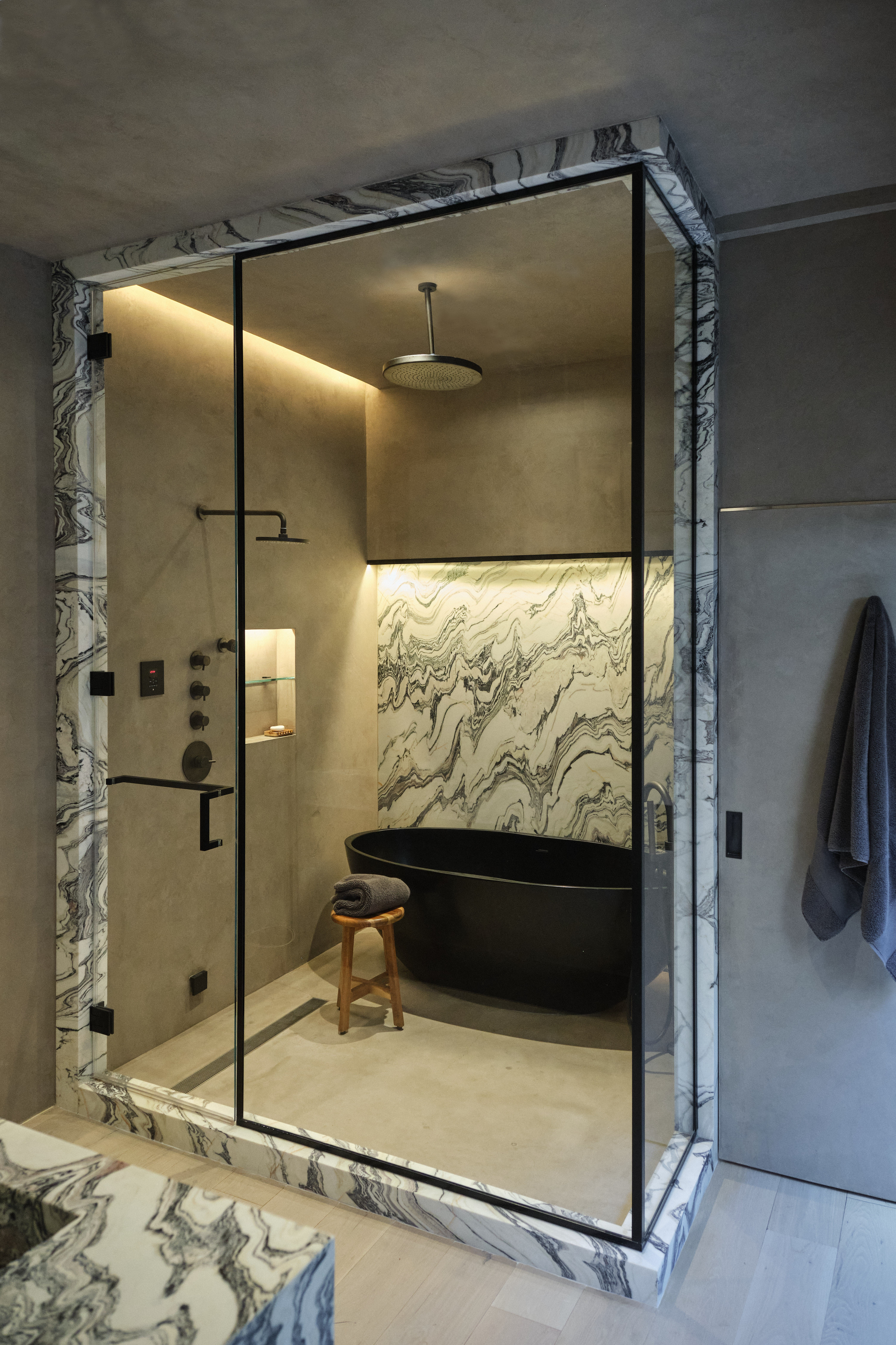 A bathroom shower with LED strip light hidden above in the ceiling, creating the effect of natural light flowing in