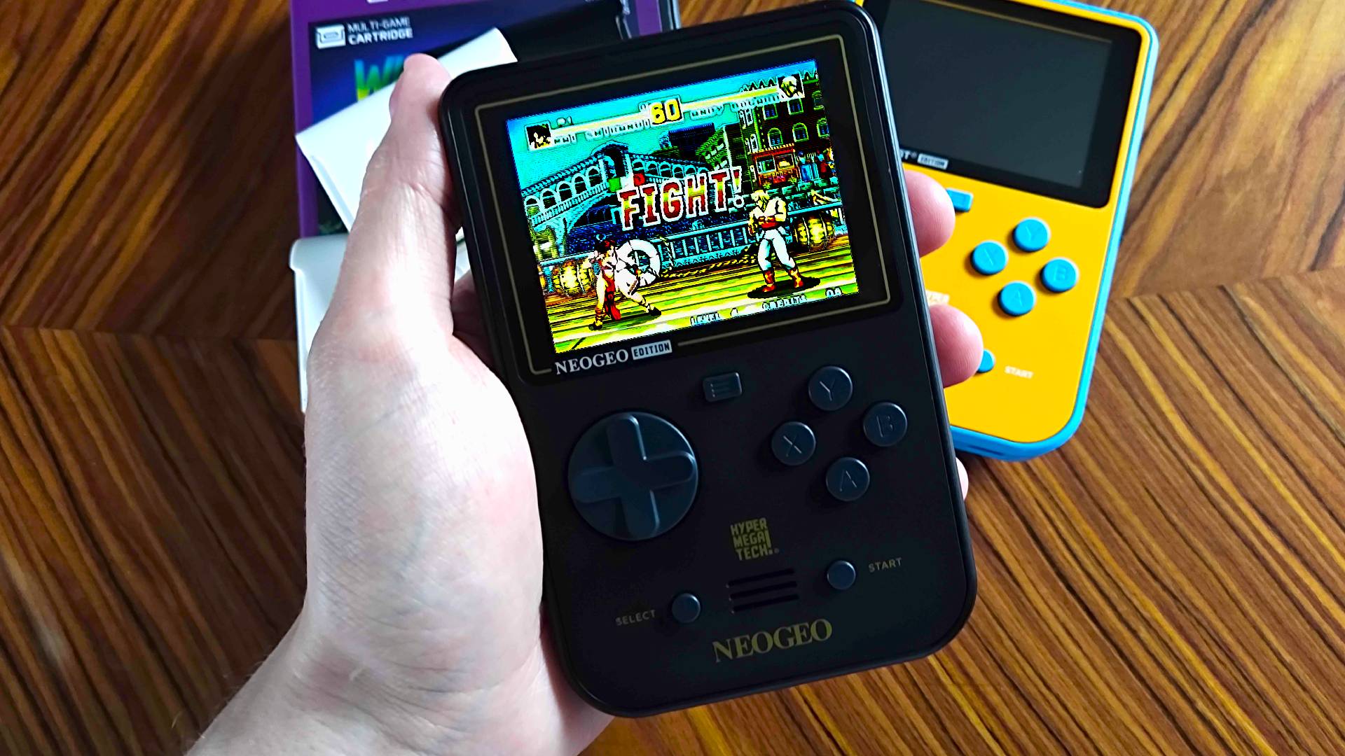 Hand holding Super Pocket Neo Geo Edition with Fatal Fury Special gameplay on screen.