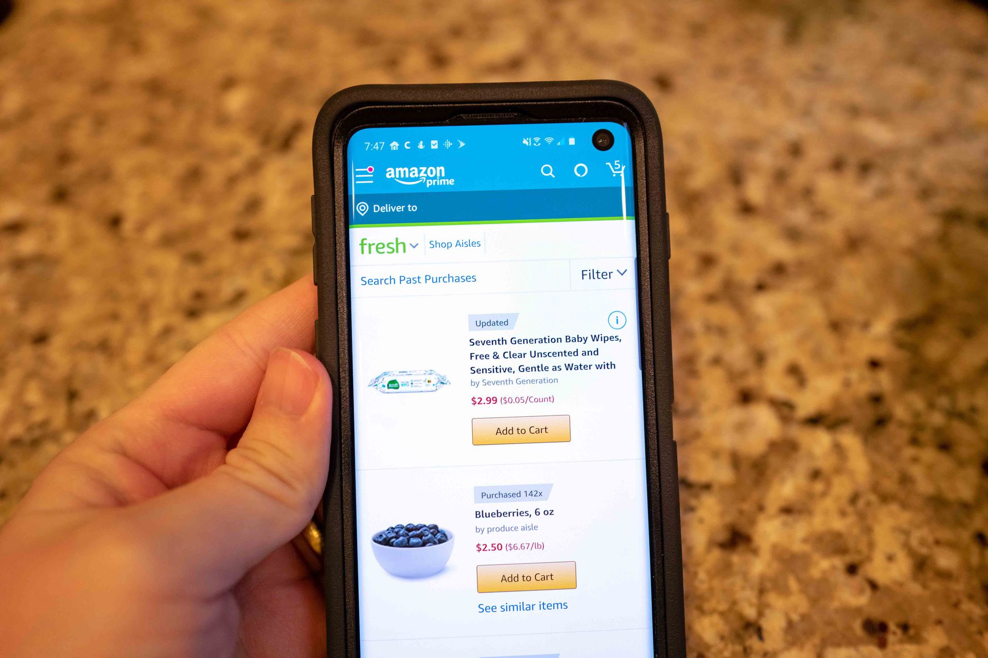 Close-up of hand of a man using the Amazon mobile app to purchase household supplies from Amazon Prime, San Ramon, California