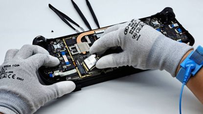 Steam Deck with back open and hands installing new SSD