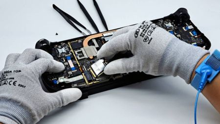 Steam Deck with back open and hands installing new SSD