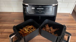The Ninja Foodi Max Dual Zone Air Fryer AF400UK having been used to cook fries and chicken wings at the same time
