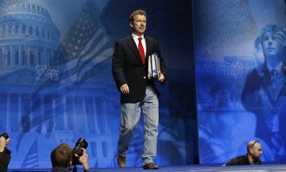 Sen. Paul holds binders, a reference to his recent 13-hour filibuster, as he arrives to speak at CPAC March 14.