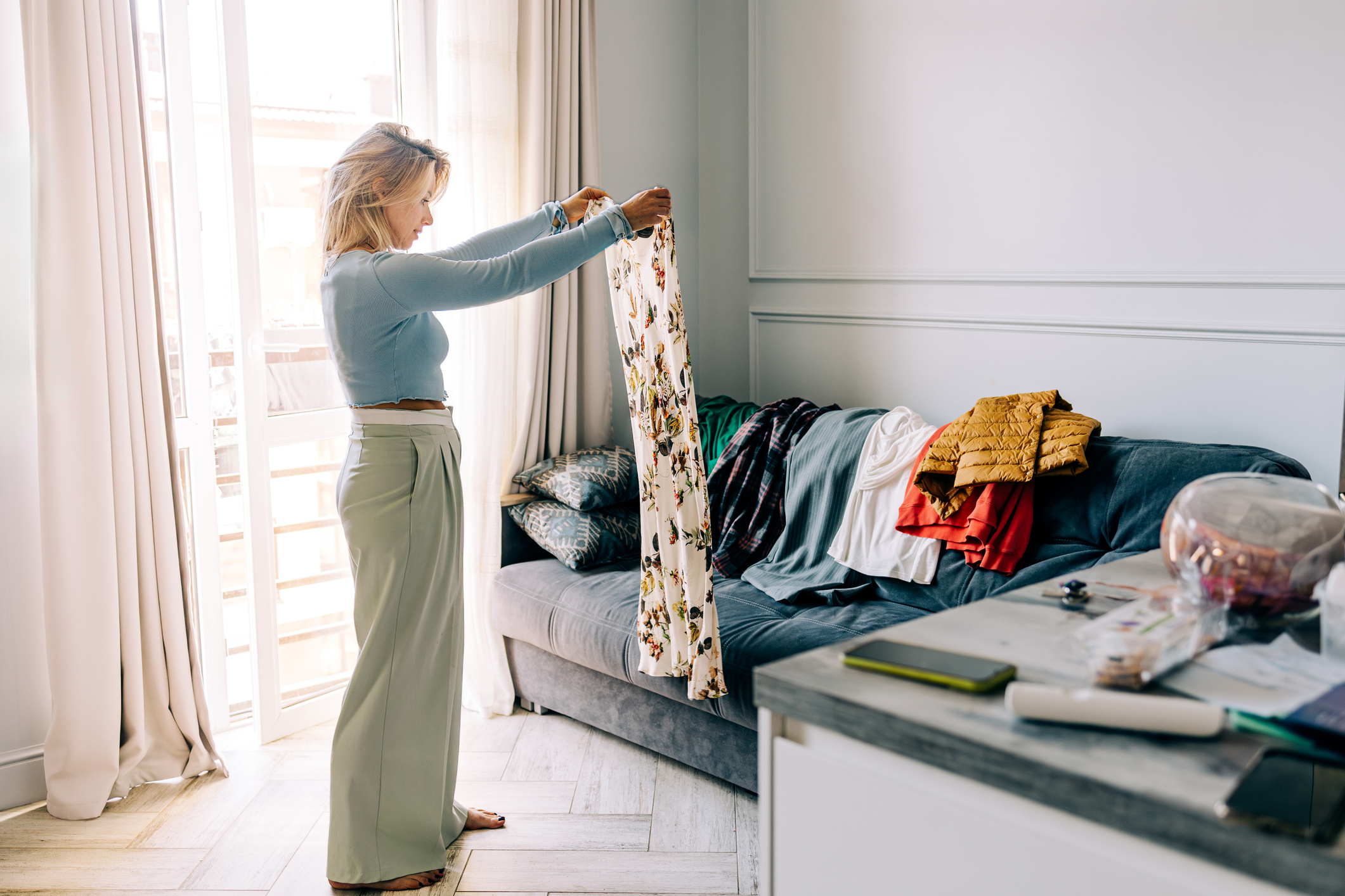 Mid adult woman organizing wardrobe and trying on clothes at home