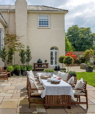 large patio dining area outside a country-style house