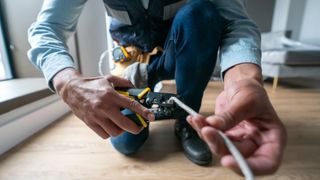 Internet technician installing a router at a house and cutting the cable