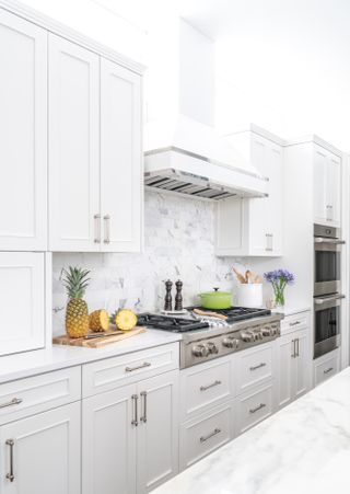 Kitchen with white cabinets and marble backsplash