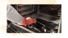 picture of a woman cleaning her oven with gloves on