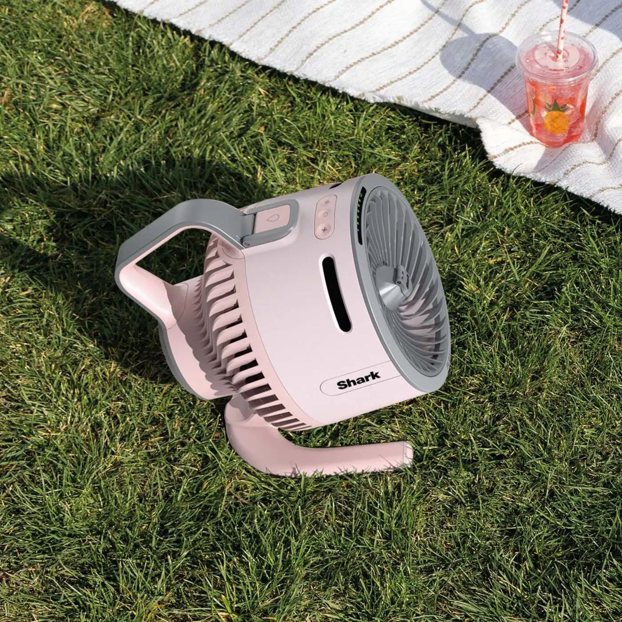 Shark FlexBreeze HydroGo fan sitting on grass next to picnic blanket