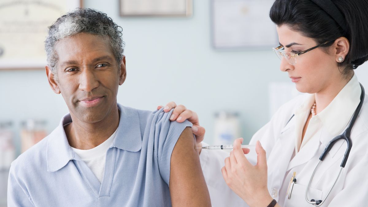 A man receiving a flu shot from a doctor