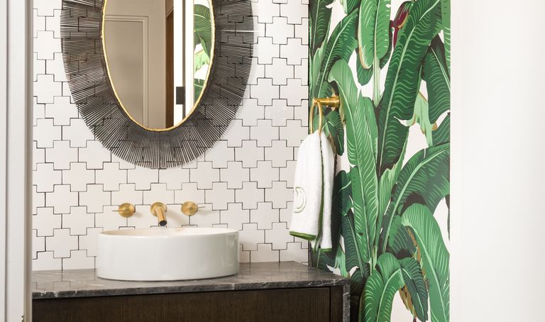 powder room with tropical banana leaf wallpaper and sunburst mirror by Maestri Studio