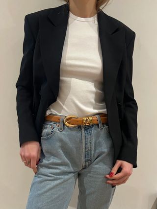 Eliza Huber wearing a white T-shirt, jeans, and a brown-and-gold Madewell belt