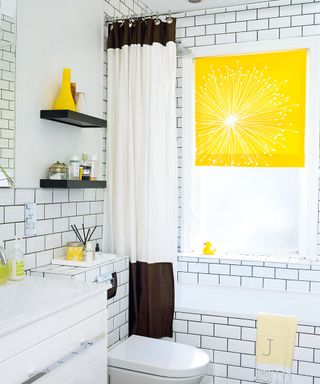 bathroom with white tiled walls and white washbasin