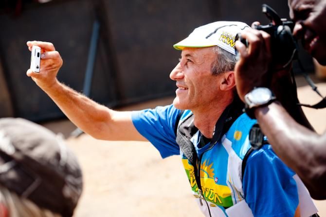 Jock Boyer (Team Rwanda) takes a picture of Adrien's Niyonshuti podium