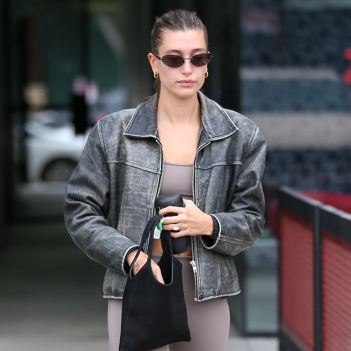 hailey bieber wearing a pilates workout set and leather jacket