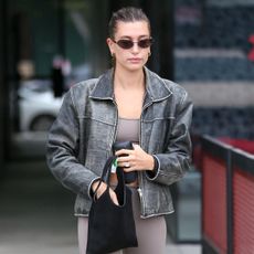 hailey bieber wearing a pilates workout set and leather jacket