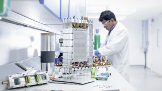 Scientist assembles lithium ion battery samples in battery research facility.