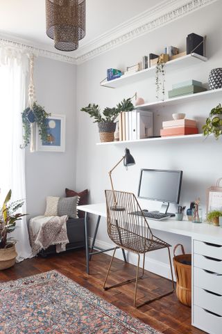 Home office with open shelving and simple white desk with drawers