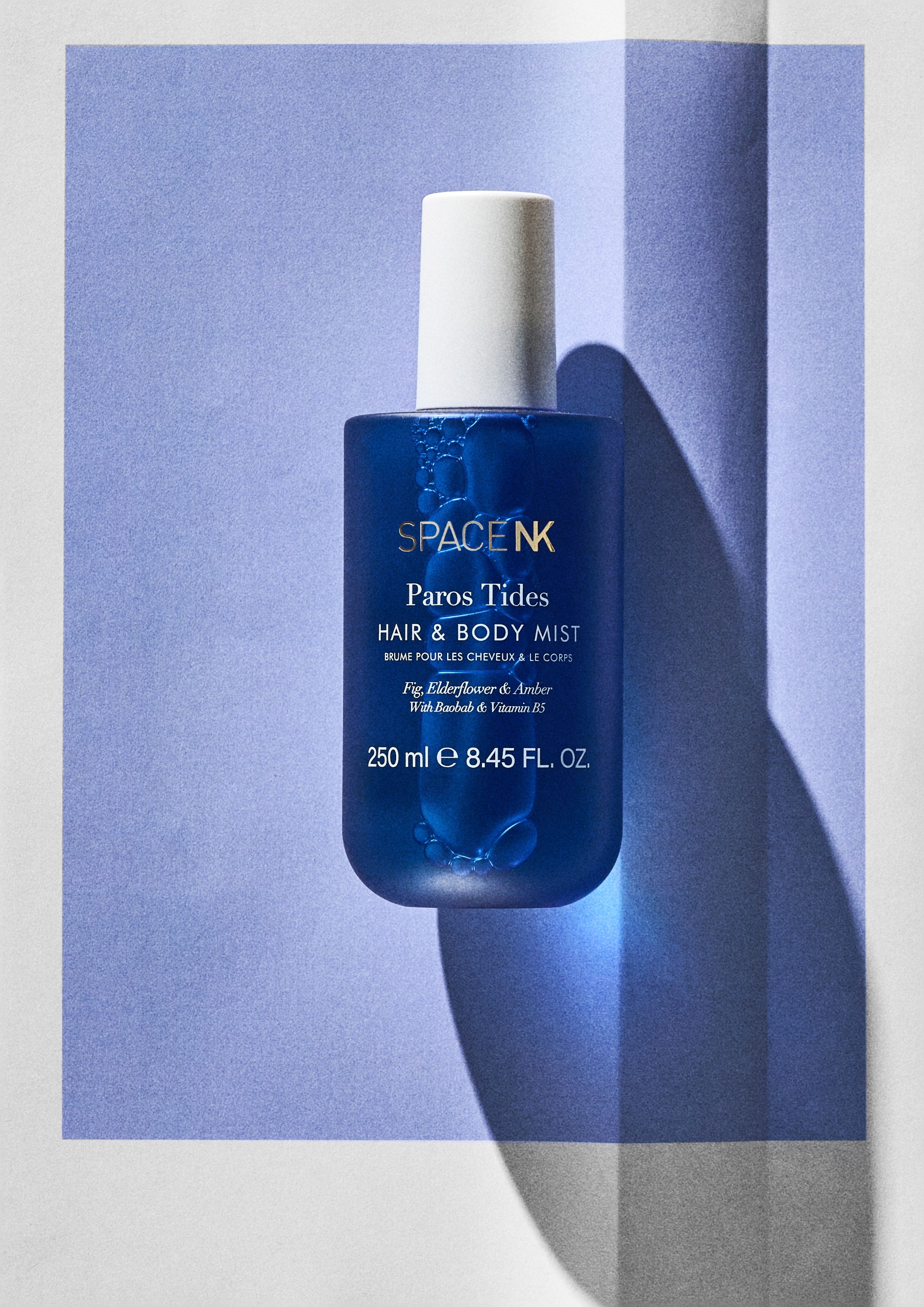 Space NK Paros Tides Hair &amp;amp; Body Mist on a blue background
