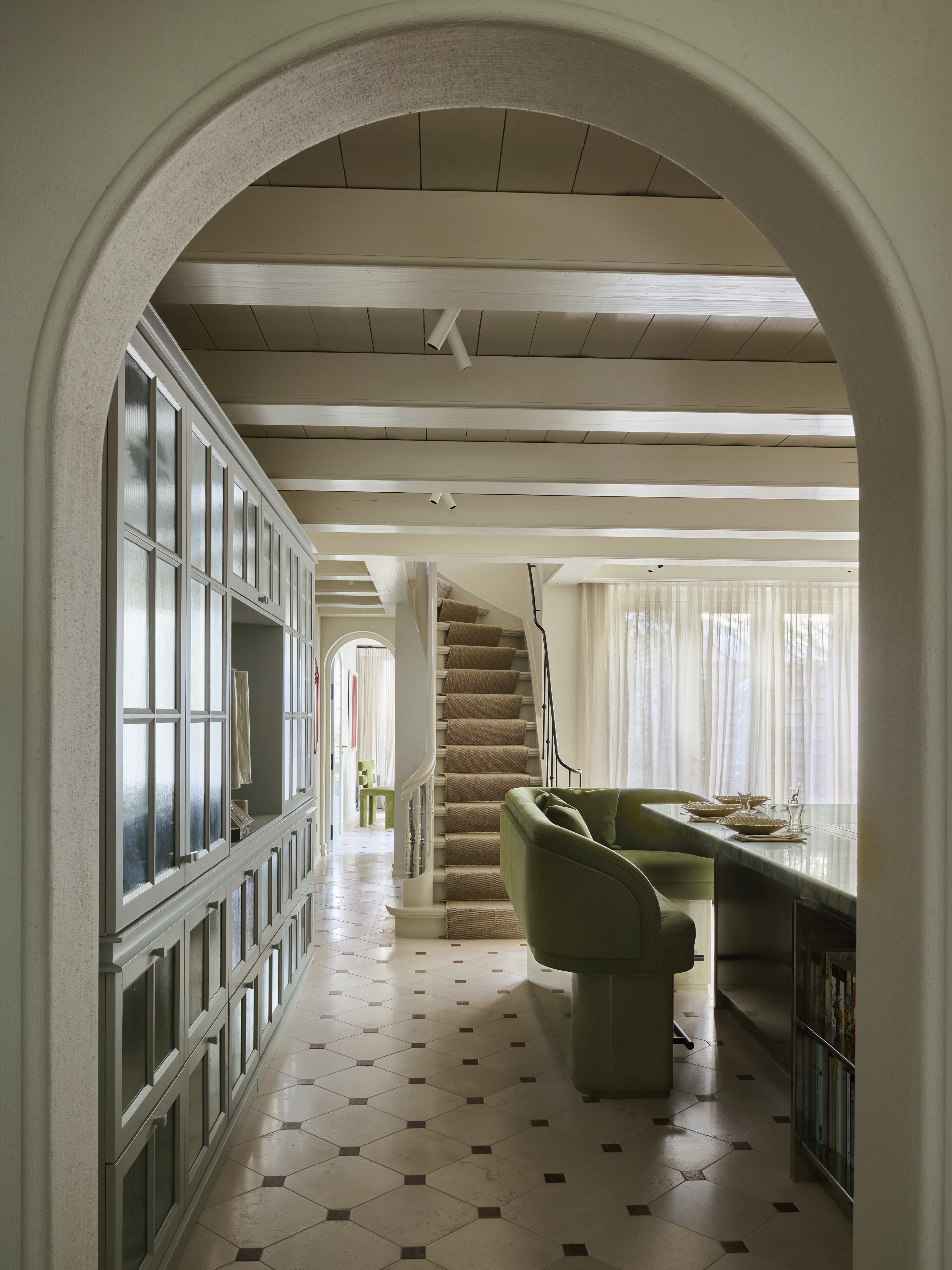 A kitchen island with a green sofa around it