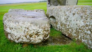 Two large stones sit in a grassy field