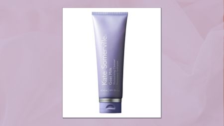 A close up of the Kate Somerville Goat Milk Moisturising Cleanser in a pastel purple, textured template