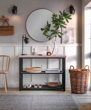 An entryway with a mirror, shelf, basket, and a chair