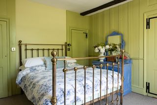 green bedroom with brass bed
