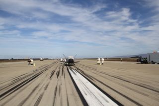 The U.S. Air Force's mysterious X-37B space plane is seen on a runway at Vandenberg Air Force Base in California after its successful landing on Oct. 17, 2014. The landing marked the end of a record-shattering 674-day mission by the robotic spacecraft.