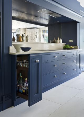 Blue kitchen cabinets with counter and induction hob above